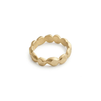 Gold ring with textured design on a light gray background