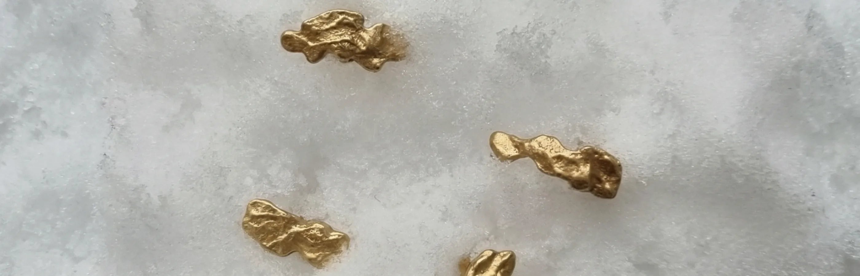 Gold mizu earrings on icy snow