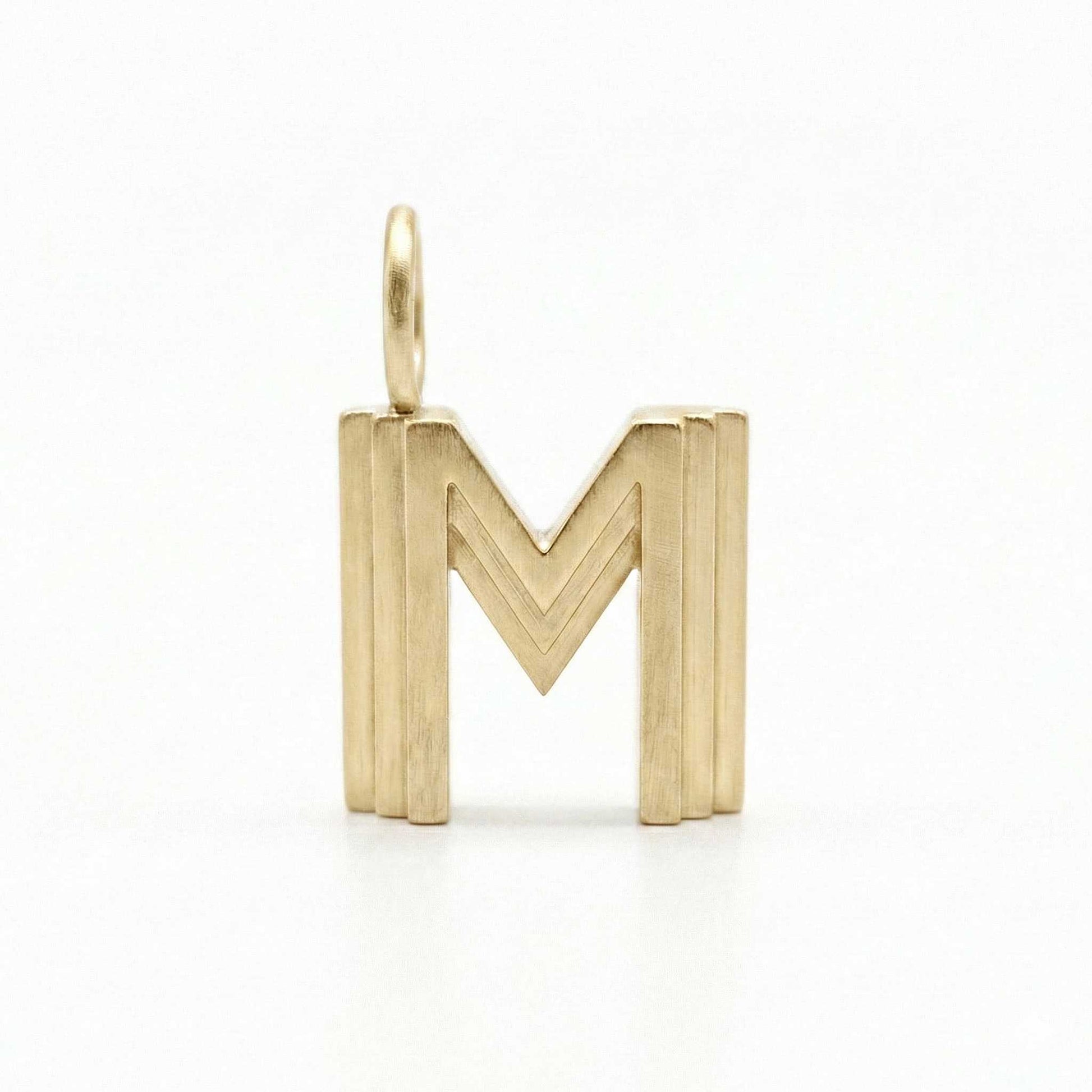 Gold letter 'M' pendant on a white background
