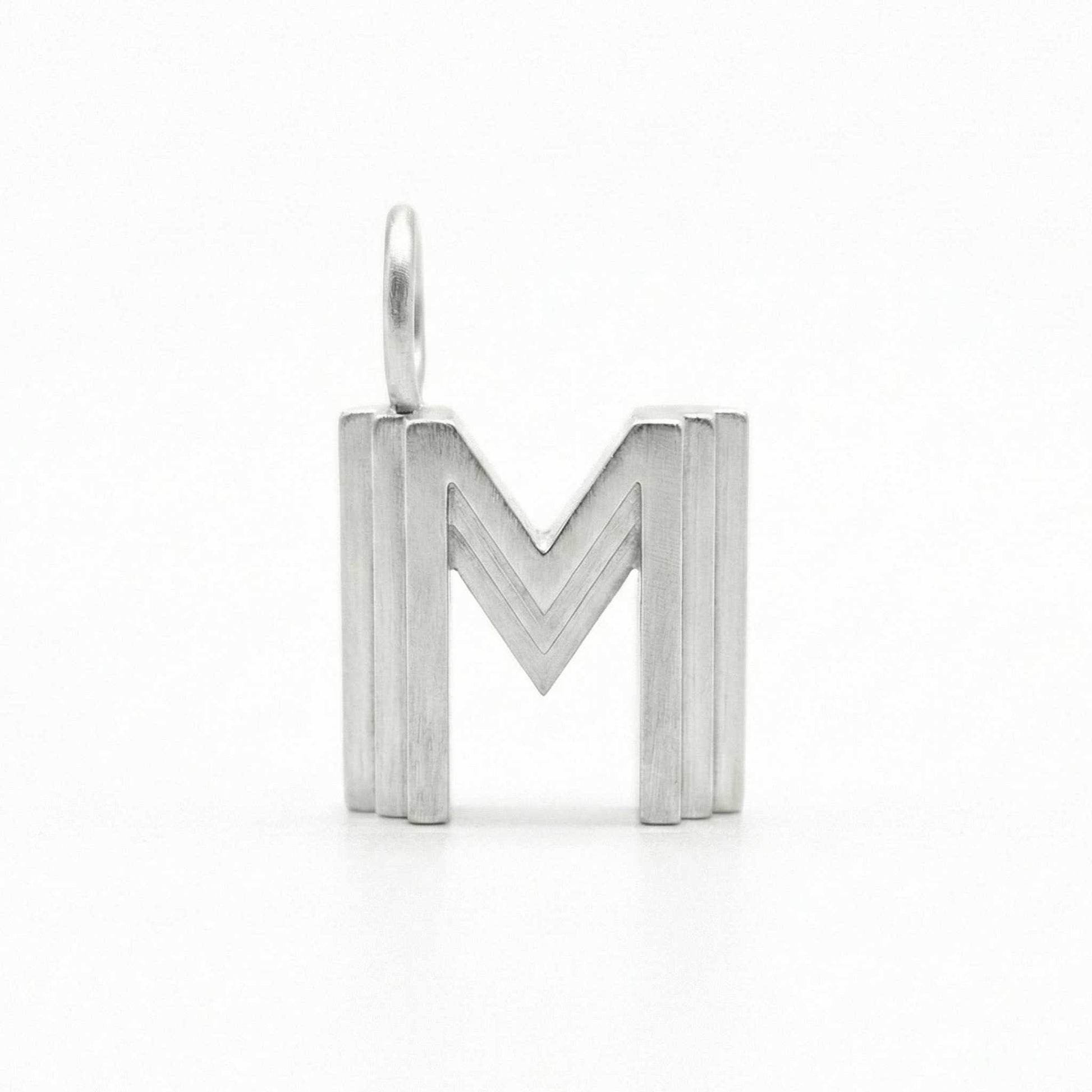 Silver letter 'M' pendant on a white background